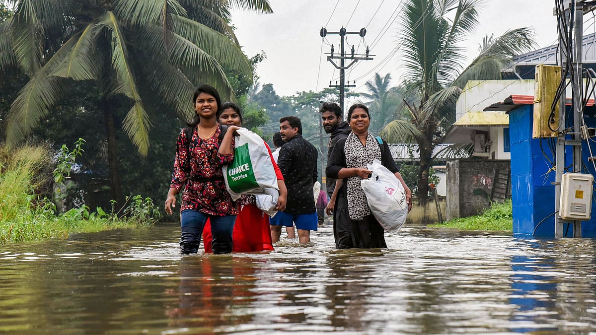 Villagers wade through a waterlogged street in Ernakulam