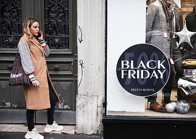 PARIS, Nov. 28, 2019 (Xinhua) -- A woman makes a phone call beside a "Black Friday" poster in Paris, France, Nov. 27, 2019. Some shops in Paris started sales promotion recently ahead of the upcoming "Black Friday" that falls on Nov. 29. (Xinhua/Gao Jing/IANS)