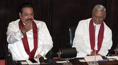 COLOMBO, Dec. 18, 2018 (Xinhua) -- Sri Lankan former President Mahinda Rajapaksa (L) attends a parliament session in Colombo, Sri Lanka, on Dec. 18, 2018. Sri Lankan former President Mahinda Rajapaksa who resigned from the prime ministerial position last Saturday was appointed as leader of the opposition at the parliament by Speaker Karu Jayasuriya on Tuesday amid objections from the ruling party. The parliament convened on Tuesday for the first time since the reinstatement of Prime Minister Ran