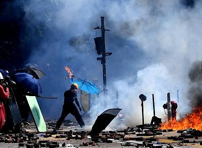 HONG KONG, Nov. 27, 2019 (Xinhua) -- A rioter sets fire and destroys public facilities outside the Hong Kong Polytechnic University in south China