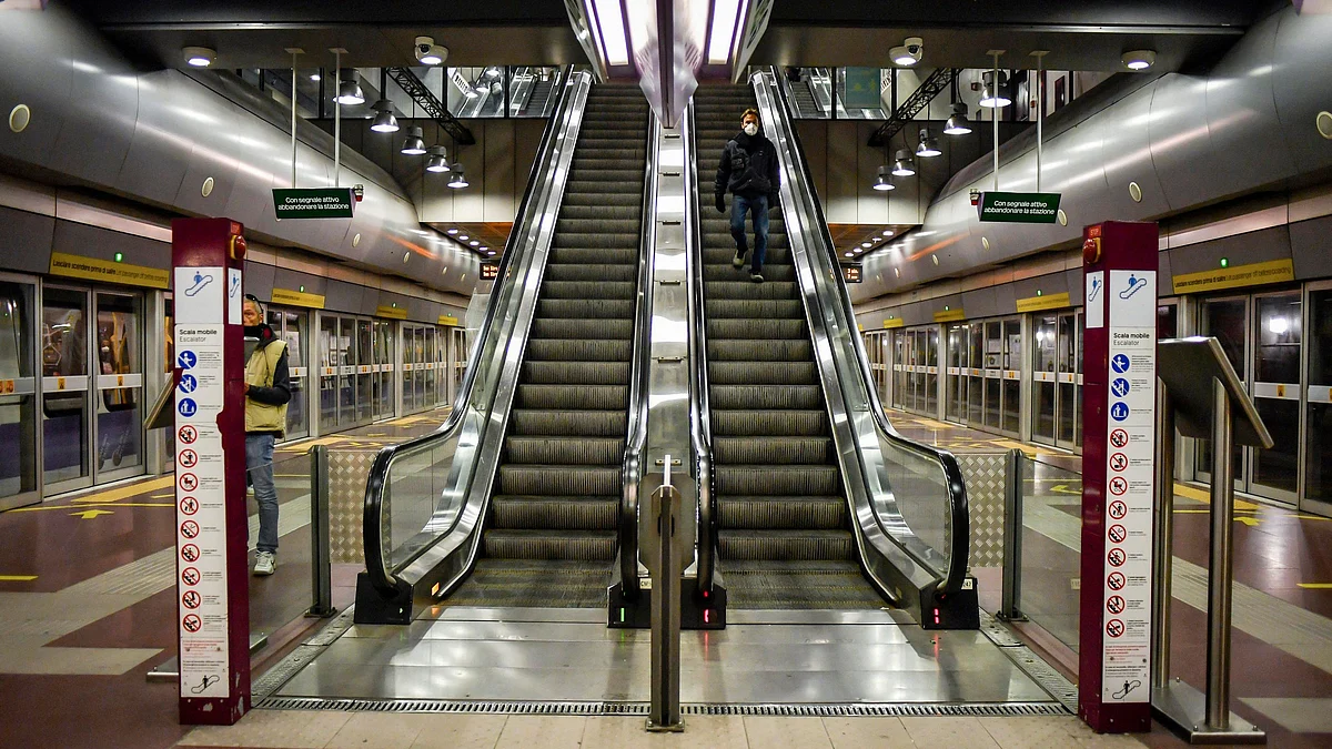 A man wearing a mask descends an escalator at a subway station in Italy’s Milan on 11 March.