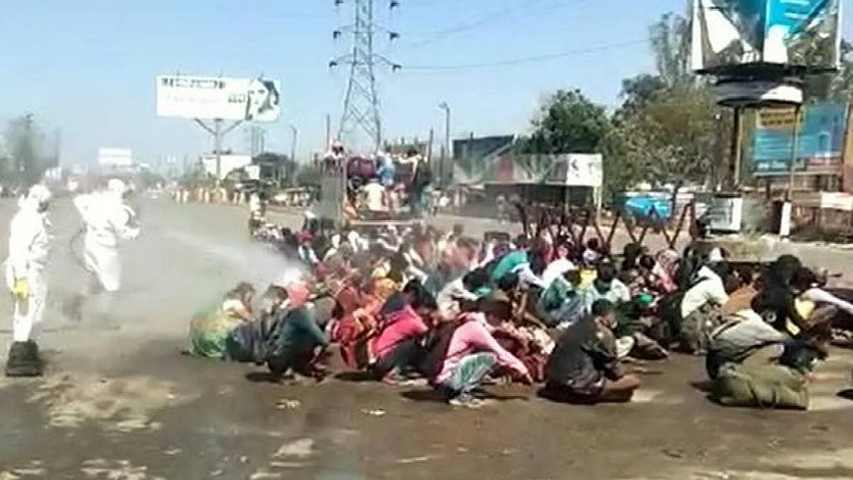 Workers at Bareilly's Satellite Bus Stand being sprayed with disinfectant.