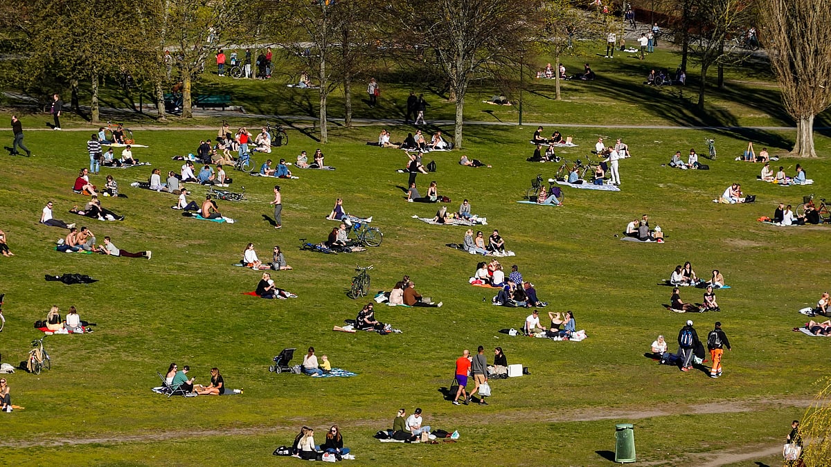 People enjoy the warm spring weather as they sit in the Hornstull, Stockholm neighbourhood during the COVID-19 pandemic.