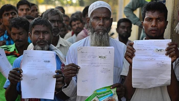 File photo of people showing their acknowledgement receipts after checking their names in a draft for National Register of Citizens (NRC), in Guwahati in January 2018. 