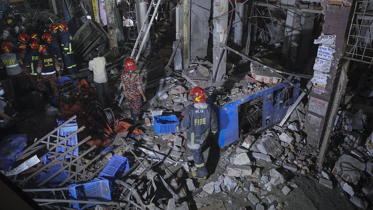 Rescuers stand amid the debris after a blast at a market in Dhaka, Bangladesh, Sunday, 27 June.