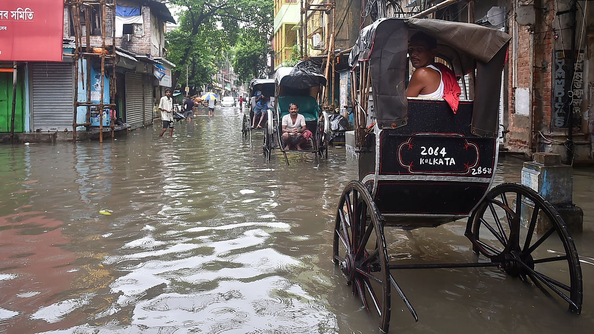 <div class="paragraphs"><p>Hand rickshaw-pullers wait for passengers at a waterlogged city road after heavy rains in Kolkata.</p></div>