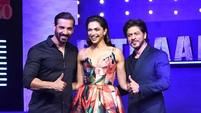 <div class="paragraphs"><p>John Abraham, Deepika Padukone, and Shah Rukh Khan pose together at<em> Pathaan's</em> first press event.</p></div>