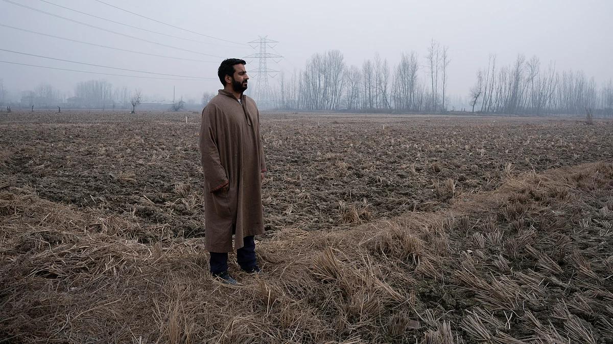 <div class="paragraphs"><p>A farmer staring into the vast rice field that is likely to be turned into a satellite&nbsp;township near the Srinagar Ring Road project.</p></div>