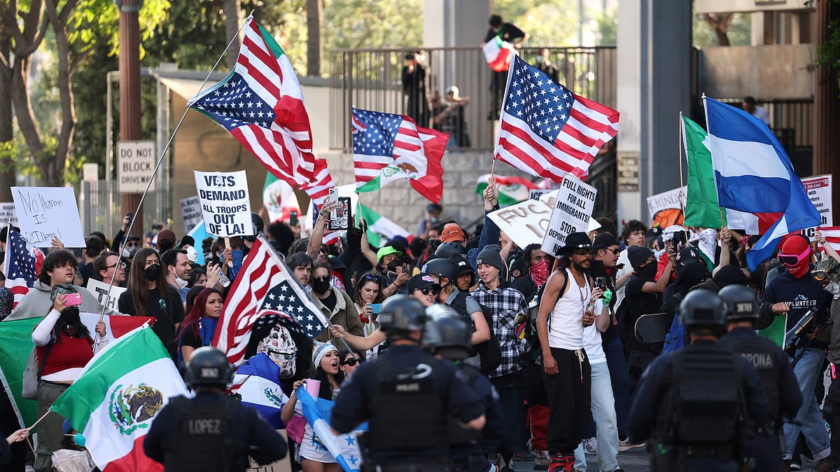 <div class="paragraphs"><p>Law enforcement officers stand guard as demonstrators protest in Los Angeles on 11 June. </p></div>