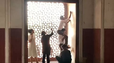 Visitors carve names on the walls of Humayun's Tomb