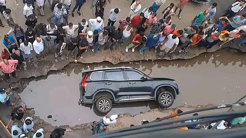 SUV submerged in pothole 