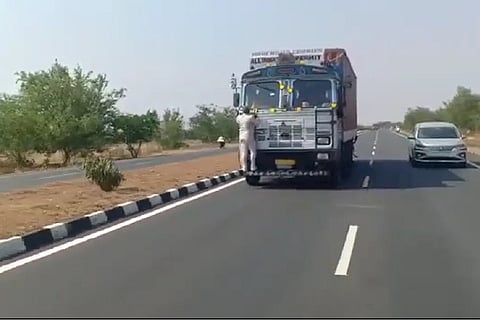 Toll official, identified as Srinivasulu, holding on to the truck as it was speeding