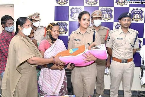 The SP handing over the baby to the mother