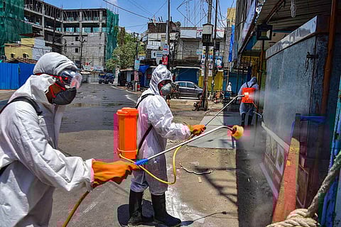 Greater Hyderabad Municipal Corporation personnel spray disinfectant on public surfaces 