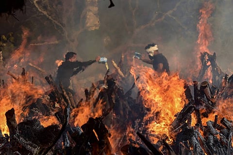 Two workers at a traditional cremation ground in India
