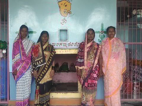 four women stand in front of blue wall temple