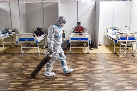 A doctor in PPE drags an oxygen cylinder at a Covid-19 Care Centre in New Delhi
