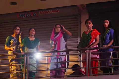 Women characters from Asangadithar film standing on the first floor and looking down