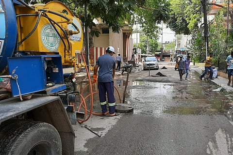 A worker clearing drains