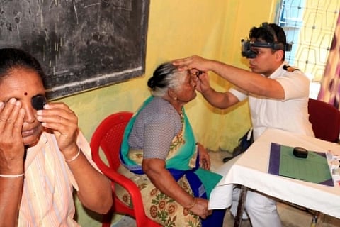 Doctor checking the eyes of an elderly woman