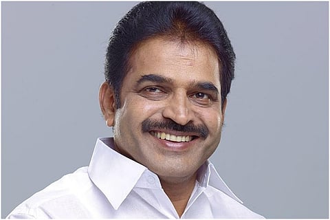 Congress leader Kerala KC Venugopal wearing a white shirt, smiling looking into the camera 