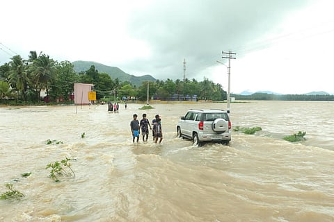 People walking on a flooded road after heavy rains in Kanyakumari 