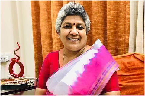 Former leader of Congress in Kerala, Lathika Subhash in a pink and white saree, posing for photo 