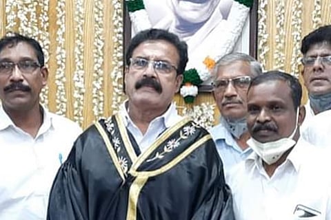 MK Varghese wearing glasses and mayor's outfit 