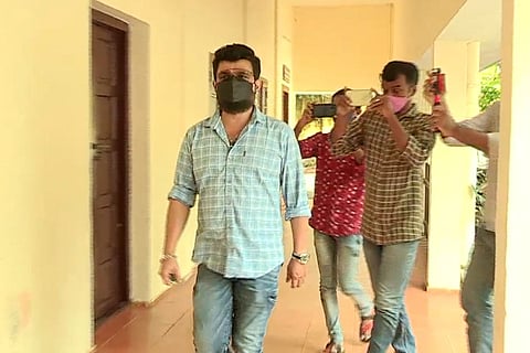 Malayalam actor Nadirshah, in a blue check shirt and wearing mask, appears before a trial court in Kochi in Actor Assault Case