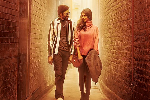 Dhanush and Aishwarya Lekshmi are seen taking a stroll in a narrow street in the image.