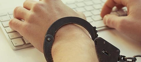 Handcuffed hands on a keyboard