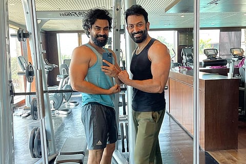Prithviraj in black and Tovino in blue taking a selfie at a gym together