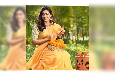 Rashmika Mandanna seen in a pale orange saree, stringing marigold in the first-look poster.