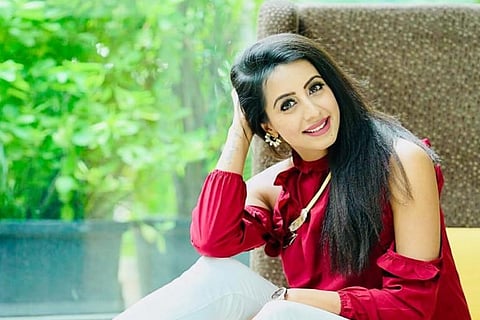 Sanjjanaa Galrani is seen wearing a red top in the image. 