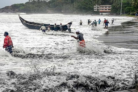 Fishermen pulling canoe back to the shore