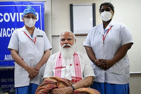 Sister P Niveda (right) and sister Rosamma Anil standing next to Prime Minister Narendra Modi who can be seen sitting in the middle