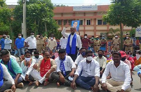 Protestors holding an Ambedkar photo staging a dharna outside the Collector's office