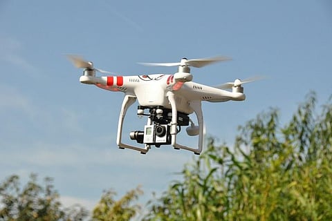 A white drone hovering in the sky