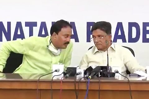 - Former Lok Sabha member VS Ugrappa on the right and the media coordinator of the Congress Party, MA Salim seated on a table for a press meet