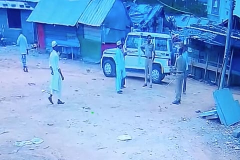 Two policemen step out from the police jeep into the Hulimangala slum near Electronic City in Bengaluru