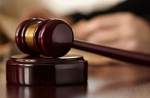 A close-up image of a wooden judge’s gavel resting on a sound block, symbolising a court verdict or judicial proceedings, with a blurred background suggesting a courtroom setting.