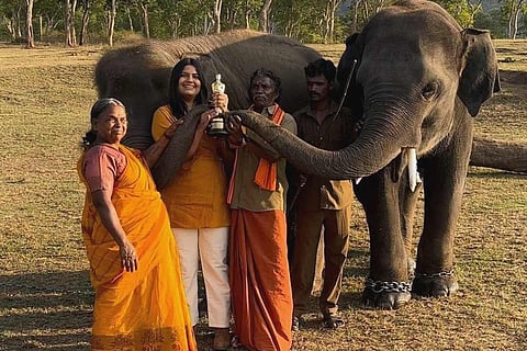 Bellie, Kartiki, Bomman, Raghu, Ammu, and a mahout pose with the Oscar trophy