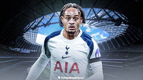 Xavi Simons wearing a Tottenham shirt in front of the Tottenham Hotspur Stadium.