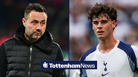 Roberto De Zerbi in a black Gillette and hoodie while looking at Tottenham's Archie Gray, who is in action during a Premier League match.