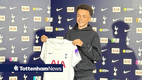 Harley Backhouse holds up a Tottenham home shirt