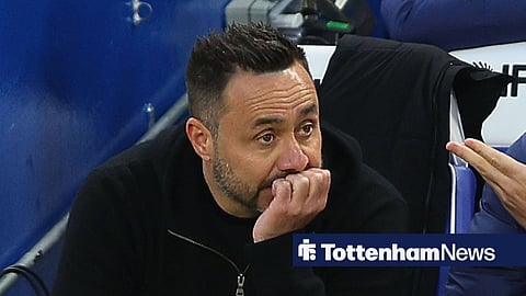 Roberto De Zerbi looking concerned while sitting on the bench managing Tottenham