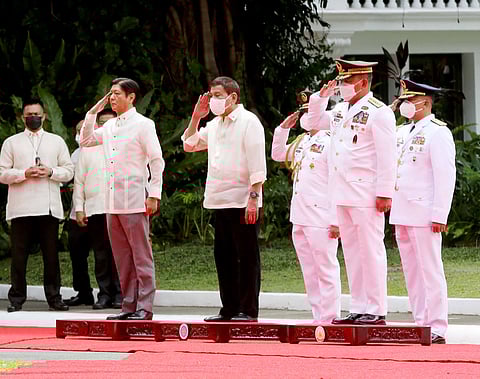 FILE: Outgoing Philippine President Rodrigo Roa Duterte (R) and his successor Ferdinand Marcos Jr. (center) during military honors at the departure ceremony of President Duterte at Malacañang Palace in Manila on 30 June 2022. 