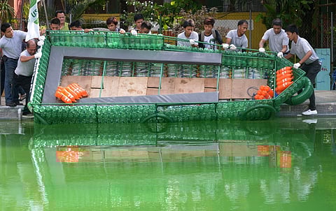 (FILES) Participants launch a craft during a competition for making rescue boats from recyclable materials in Manila on 2 October 2013. The competition is sponsored by the Manila government as the city is prone to flooding during torrential monsoons. 