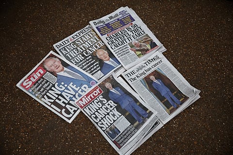 A picture shows newspaper frontpages about Britain's King Charles III's cancer outside Buckingham Palace in London on 6 February 2024. King Charles III has been diagnosed with cancer and has begun treatment, Buckingham Palace said on 5 February, sparking a flood of support from around the world. 