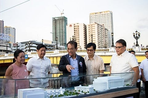 Department of Human Settlements and Urban Development Secretary Jose Rizalino Acuzar  (third from left) shows President Ferdinand Marcos Jr. and the First Lady, Liza Araneta-Marcos  with (fourth and fifth from left) Interior and Local Government Secretary Benhur Abalos Jr. and Metropolitan Manila Development Authority acting chairperson Atty. Romando Artes a model edifice for the Marcos Jr.’s  Pambansang Pabahay Para sa Pamilyang Pilipino Program being undertaken with DHSUD in the lead. 